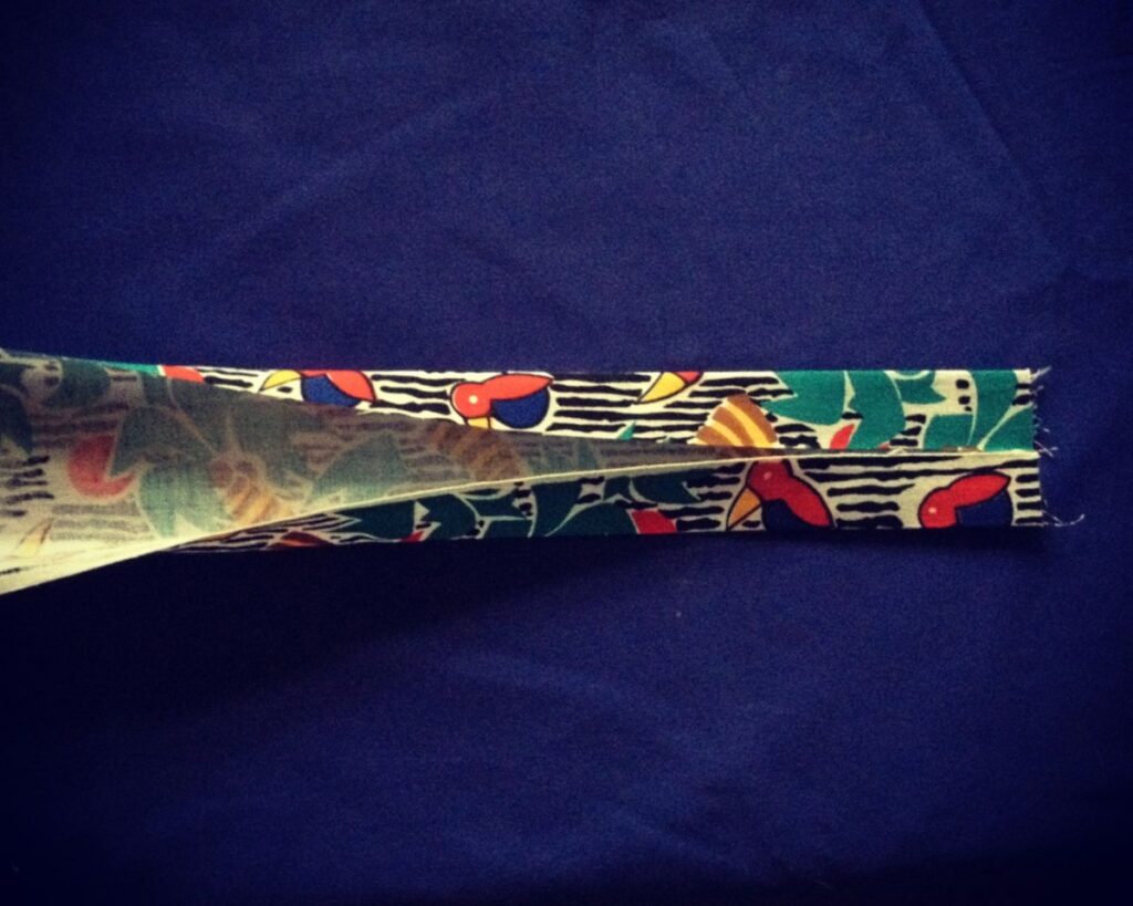 Demonstrating an element of this pattern for a tote bag - how to fold the handles for ironing before sewing.