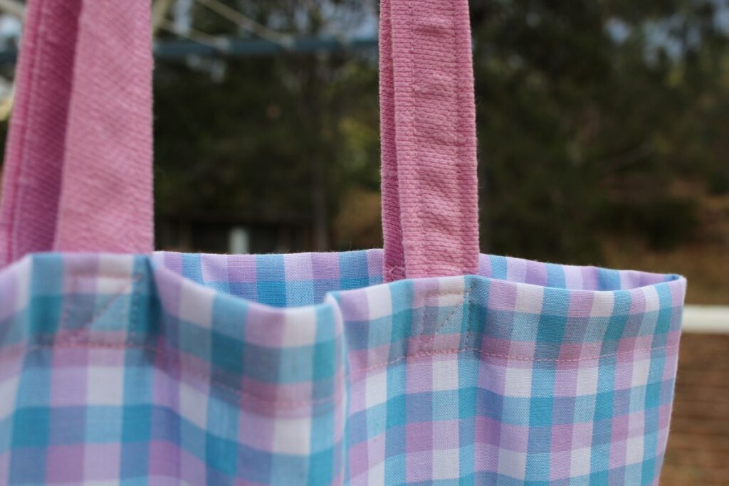 A close up of the box sewing technique used to secure the straps to this shoulder tote bag.