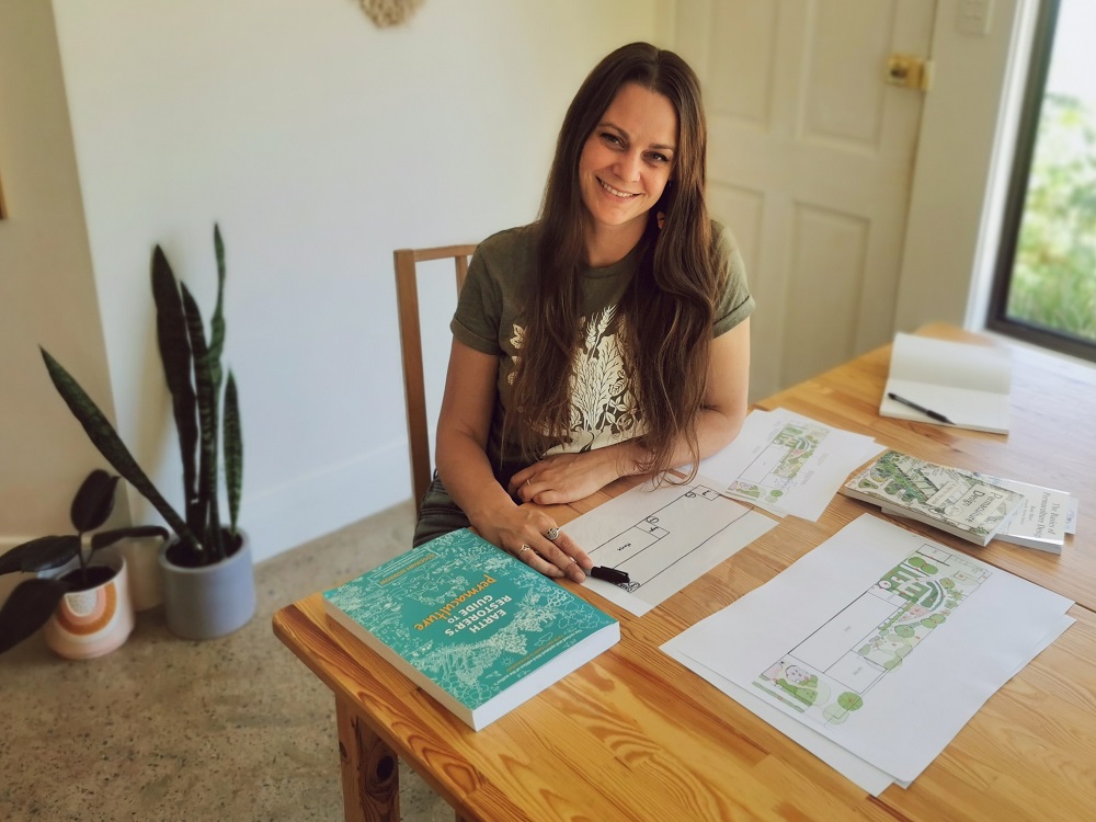 Koren with her permaculture garden plans and key reference books