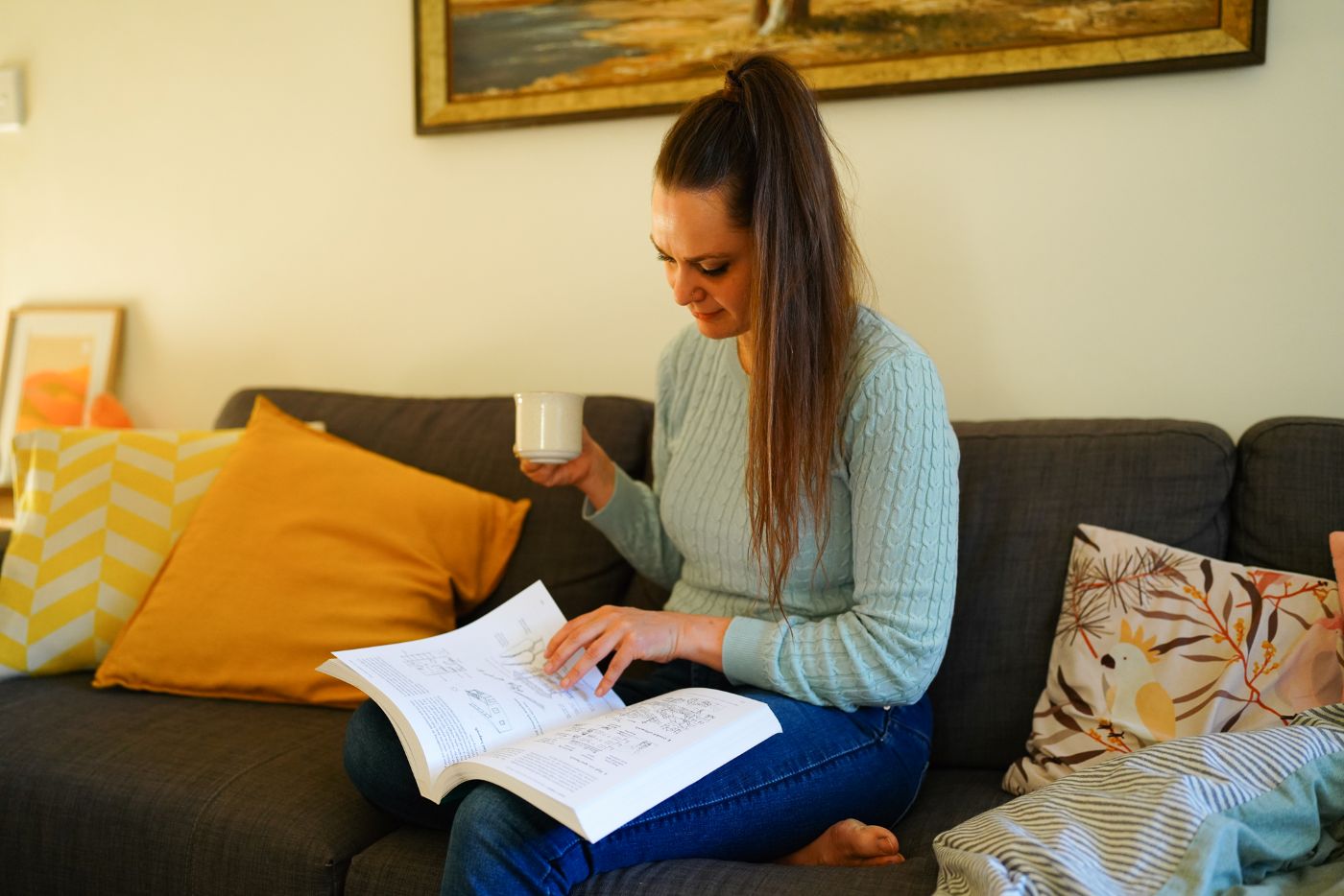 Koren Helbig on the couch reading a book, during a quarterly rest week.