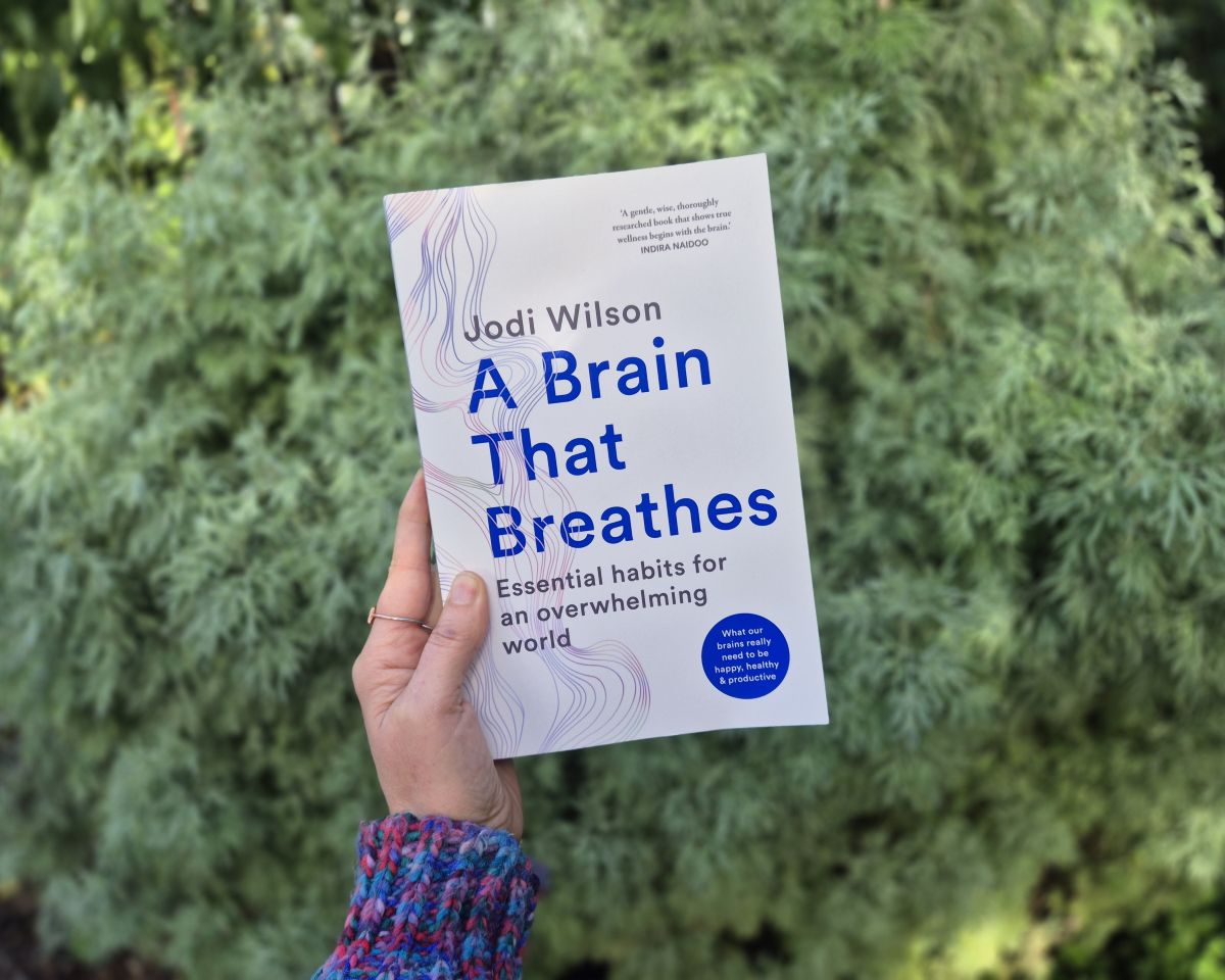 A white hand holding the book, A Brain That Breathes