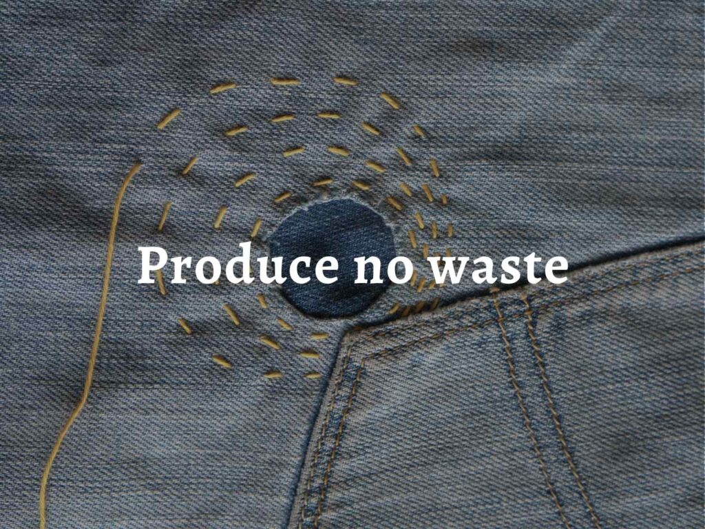 A pair of jeans with visible mending in yellow thread, over which are laid the words: 'Permaculture principle 6: Produce no waste'